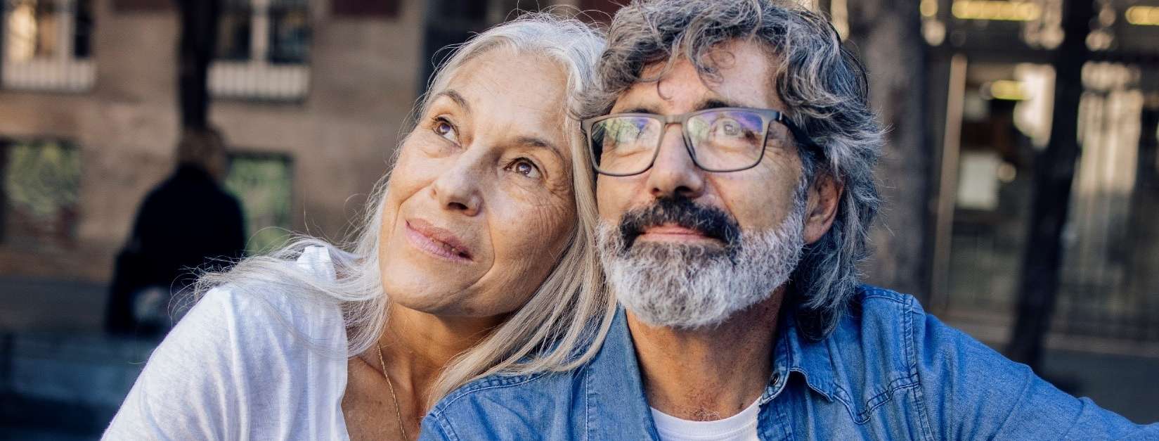 Allianz Pension Partners: Die Zukunft ist jetzt. Ein Paar sitzt nebeneinander und blickt gemeinsam in die Ferne.