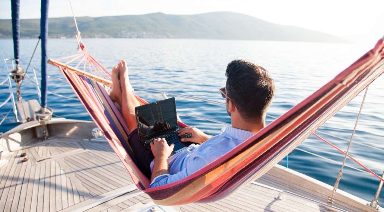 Meine Allianz | Ihre Versicherung online. Mann sitzt mit Laptop vor einer Bergkulisse