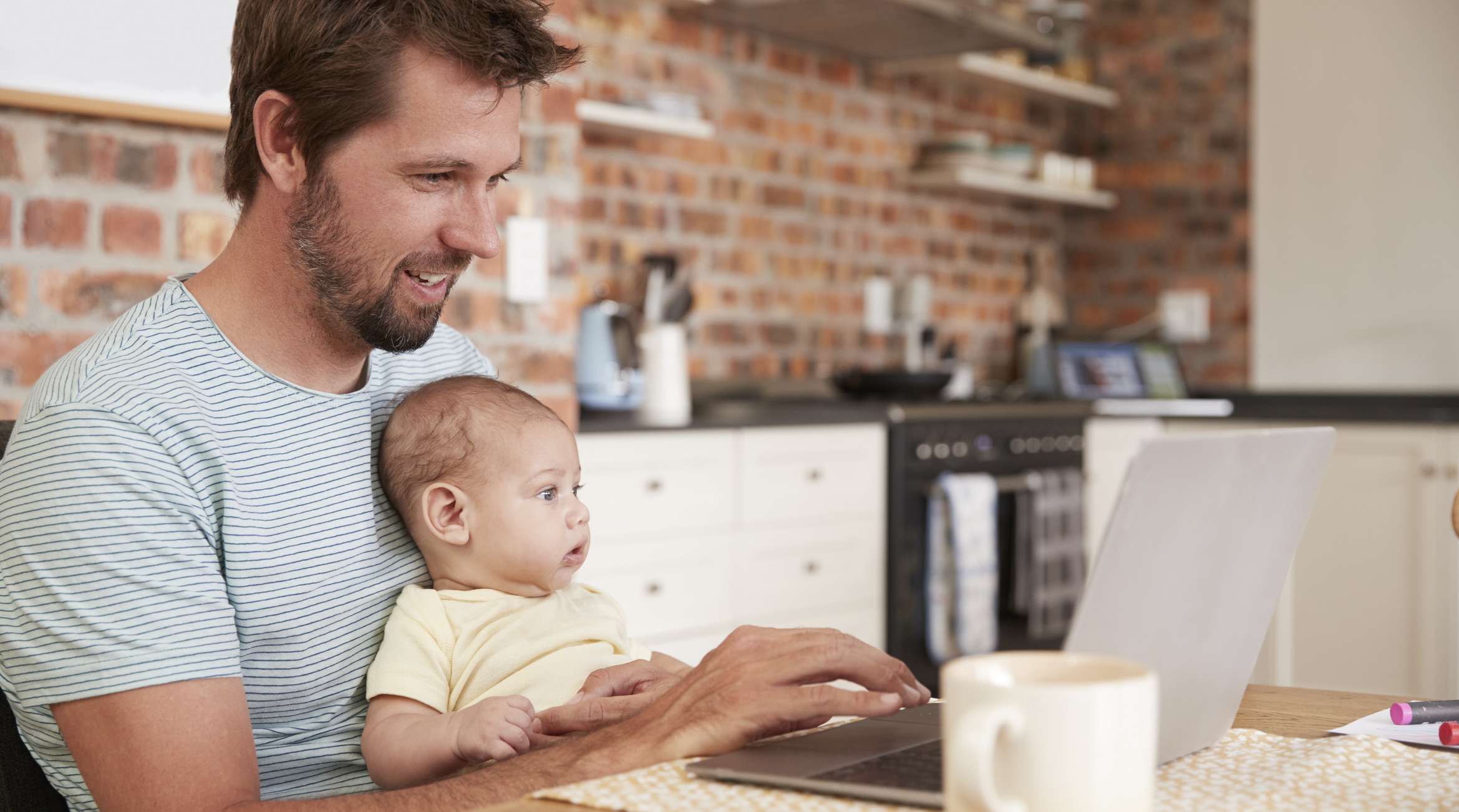 Vater arbeitet Zuhause mit Baby: Riesterrente