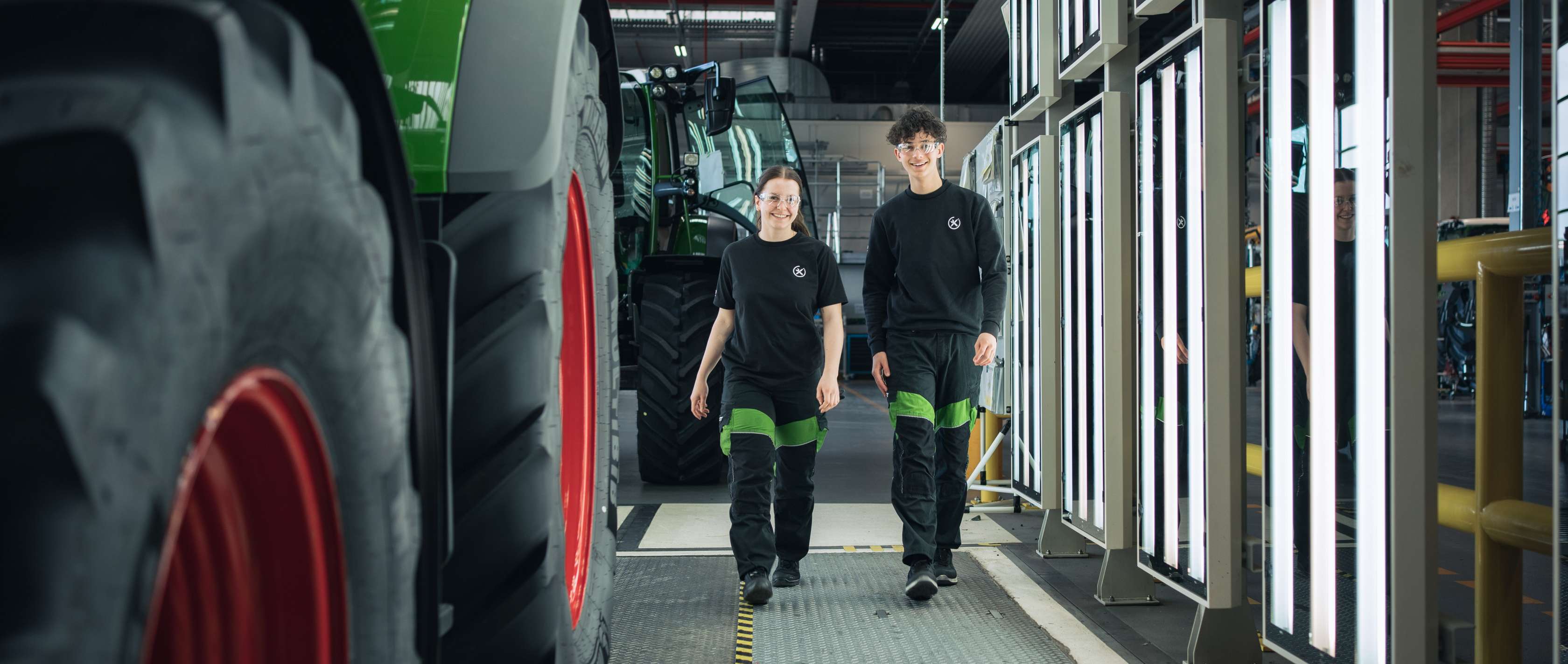 Allianz Pension Partners: MetallRente. Zwei junge Personen sind in einer Lagerhalle.